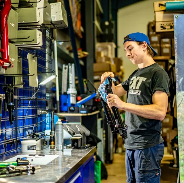 Mechanic with serviced shock at HPR Suspension workshop in Terrey Hills, Northern Beaches